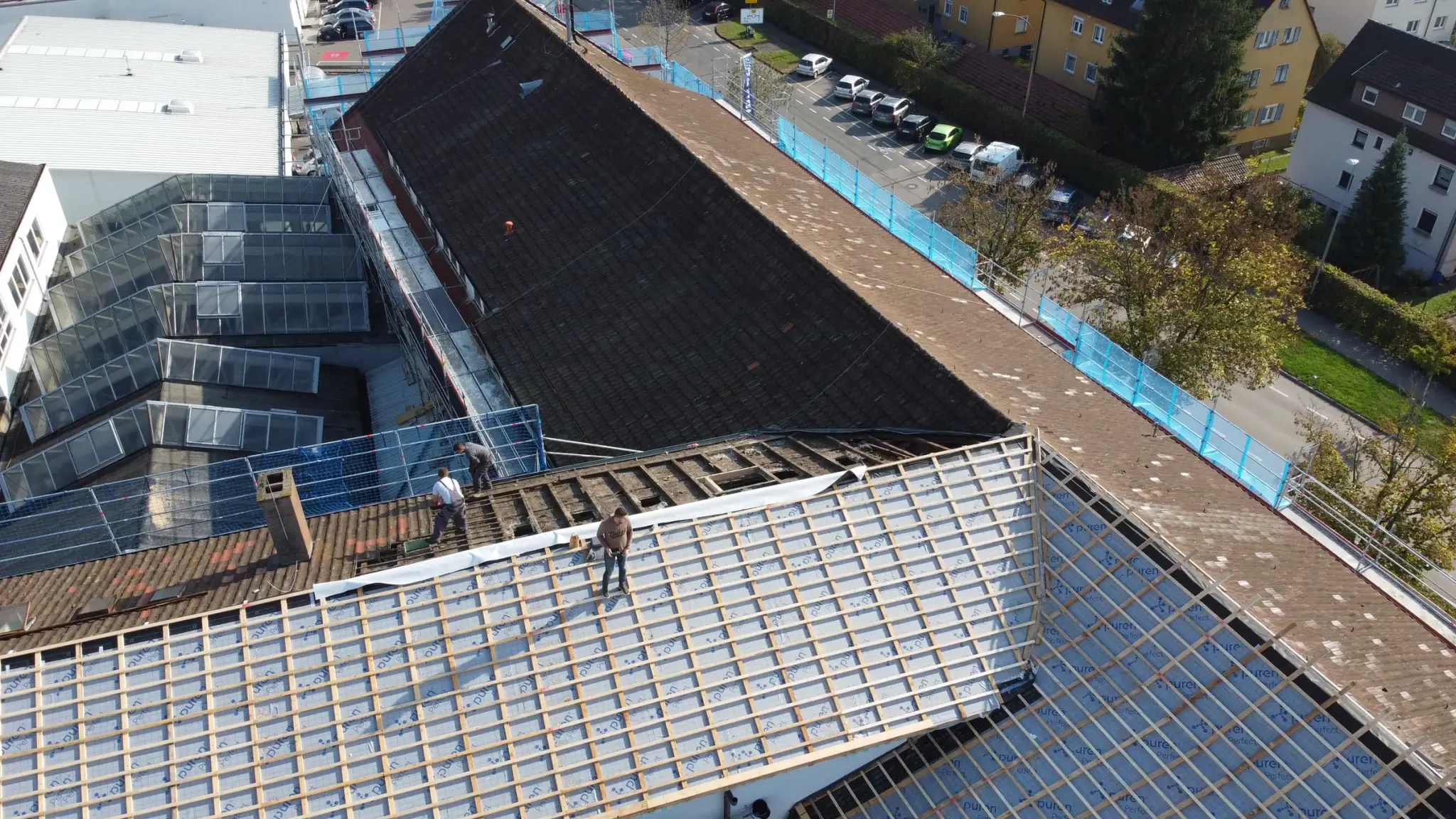 Teilweise abgedecktes Gewerbedach mit neuer Unterdeckbahn und Lattung